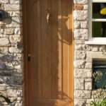 arched oak door with dolphin knocker
